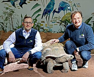 Steffen Karcher (links) und Dr. Matthias Reinschmidt im Exotenhaus bei den Riesenschildkröten: Über deren bereits vorhandenem Außengehege soll eine große Voliere gebaut werden, die dann auch von den Vögeln und Affen aus der Halle genutzt werden kann. Finanziert wird der Bau durch die Erbschaft. 