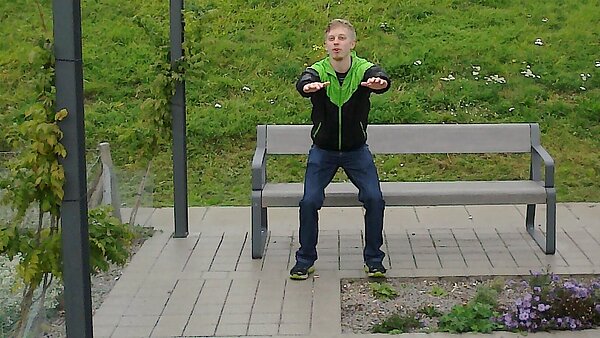 Sportstudent im Fitnessparcour Ost, der Bewegungsübungen vormacht