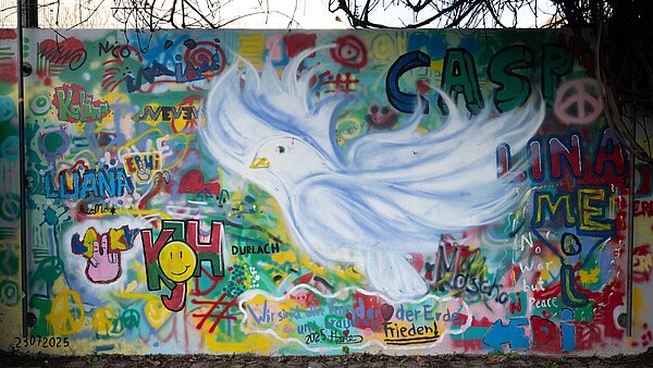 Eine neugestaltete Wand im Weiherhofgrünzug mit großer Friedenstaube im Zentrum