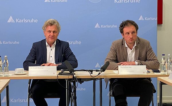 Oberbürgermeister Dr. Frank Mentrup und Maximilian Lipp sitzen vor einer Pressewand. 