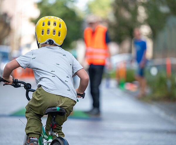 Kind fährt auf Straße mit Fahrrad