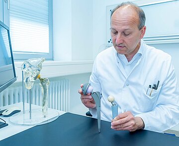 Prof. C. Müller vom Städtischen Klinikum in Karlsruhe stellt ein künstliches Gelenk vor.