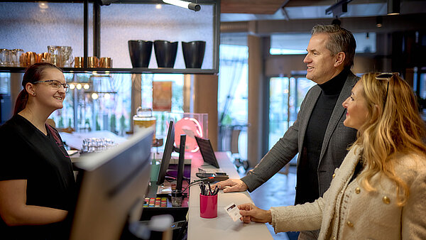Hier ist ein Paar an der Hotelrezeption zu sehen.