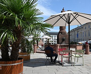 Sitzmöglichkeit unter Sonnenschirm auf dem Marktplatz in Karlsruhe