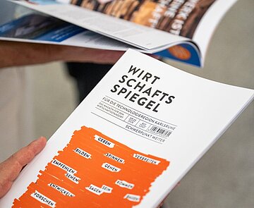  Wirtschaftsspiegel 2026 wird von Personen in der Hand gehalten