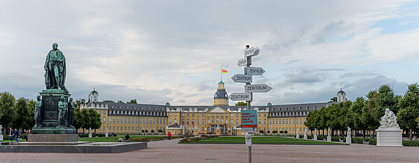 Karlsruher Schloss, davor Wegweiser der in alle möglichen Richtungen "Zentrum" anzeigt
