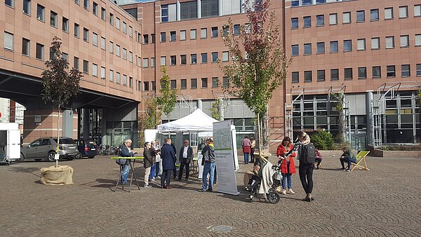 Personen vor einem Infopavillon