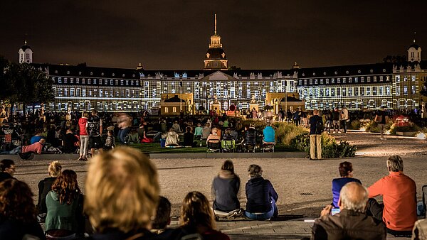 Das bunt angeleuchtete Schloss fasziniert das Publikum während der Karlsruhe Schlosslichtspiele.