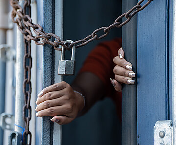 Frau ist in Cargo Container eingesperrt und versucht dieses von innen zu öffnen. 