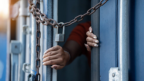 Frau ist in Cargo Container eingesperrt und versucht dieses von innen zu öffnen. 