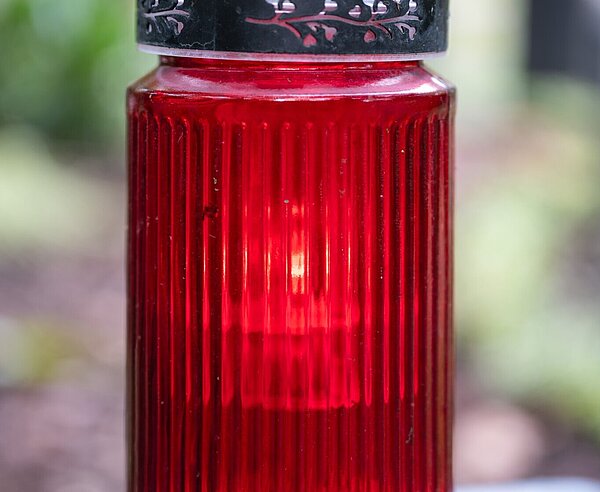 Grablicht bei  Grab stehend