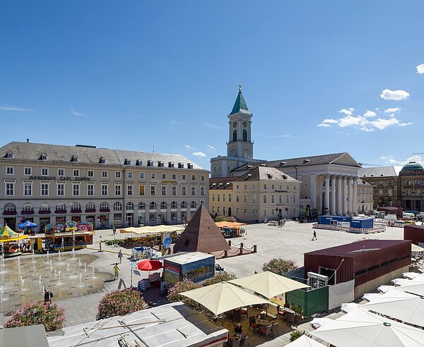 Blick von oben auf den Marktplatz  Richtung Osten im Sommer mit Wasserspiel und Menschen