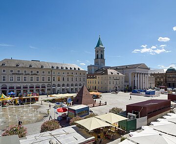 Blick von oben auf den Marktplatz  Richtung Osten im Sommer mit Wasserspiel und Menschen