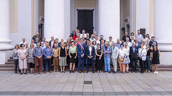 Gurppenfoto Städträte und Stadträtinnen aus Karlsruhe und Nancy vor der Evangelischen Stadtkirche