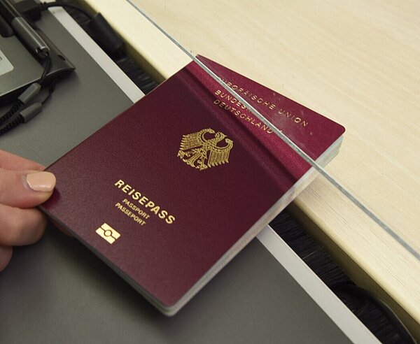 Händische Übergabe eines beantragten Reisepasses im Bürgerbüro