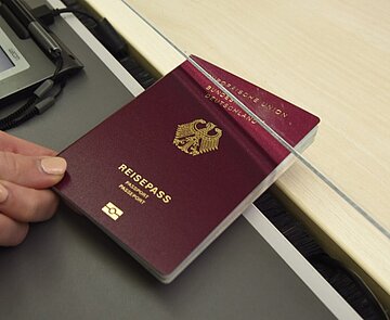 Händische Übergabe eines beantragten Reisepasses im Bürgerbüro