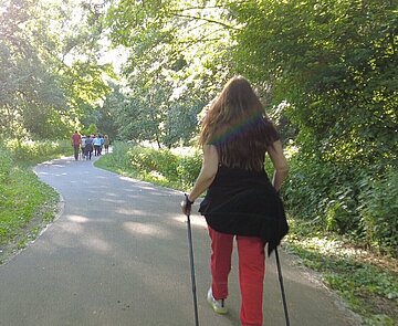 Das Foto zeigt eine Gruppe beim Nordic Walking draußen in der Natur.