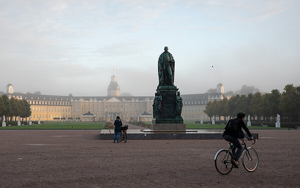 Radfahrende im Herbst, vor dem Karlsruher Schloss.