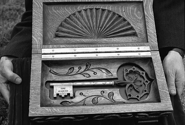 Symbolischer Schlüssel in einer gestalteten Holzkiste