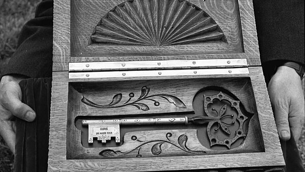 Symbolischer Schlüssel in einer gestalteten Holzkiste