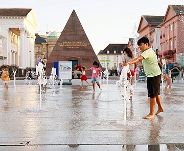 Kinder die in den Wasserspielen herumlaufen