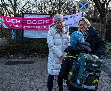 Bürgermeisterin Yvette Melchin (links) und Ortsvorsteherin Elke Ernemann übergeben einem Schüler eine Trinkflasche.