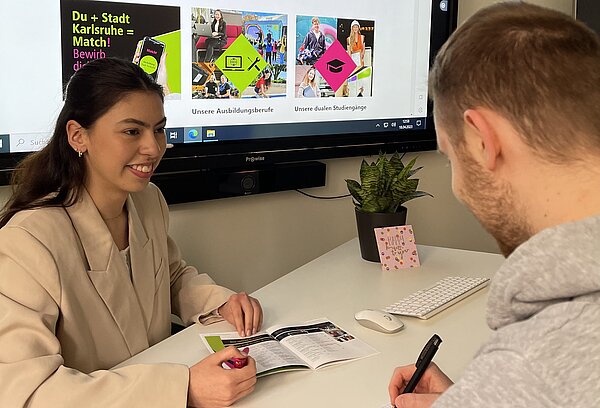 Auszubildende berät Bürger.