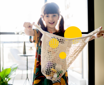 Keyvisual der Tatenbank - Kind das einen Beutel mit gelben Sphären nach vorne streckt