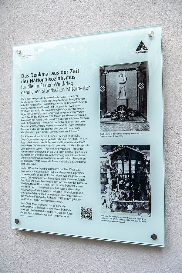 Eine Informationstafel kommentiert das Gefallenenmal im Ehrenhof des Karlsruher Rathauses.