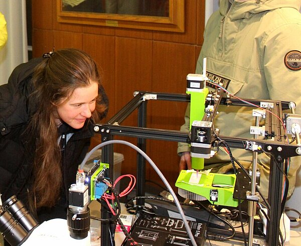 Studierende und Doktoranten nehmen in der Ausstellung im Rathausfoyer einen 3D-Bio-Drucker genauer unter die Lupe.