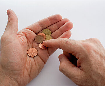 Zwei Hände mit Euro-Cent-Münzen, es wir das letzte Kleingeld gezählt.