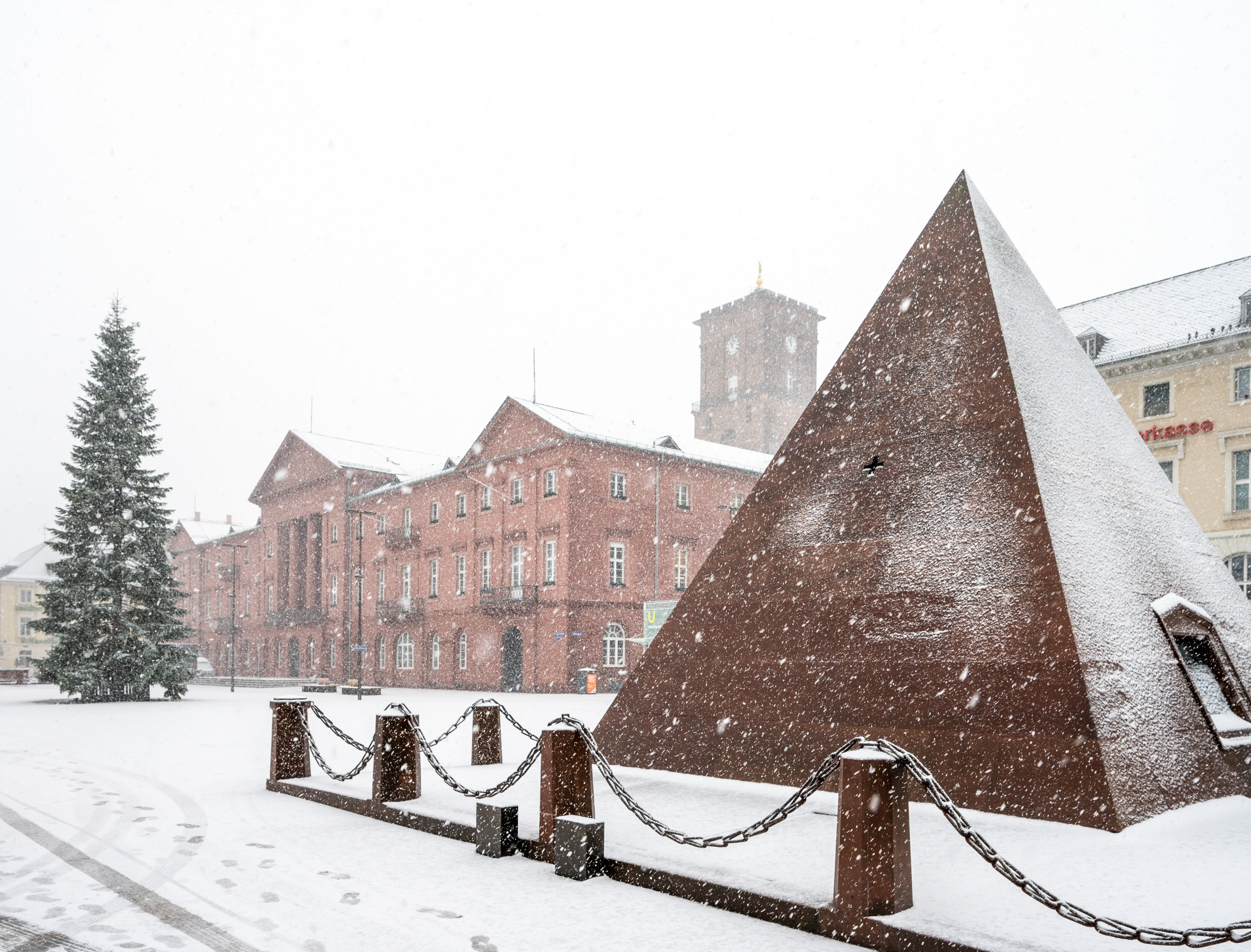 Blick auf eine verschneite Szenerie des Karlsruher Marktplatzes. Im Vordergrund die Pyramide.