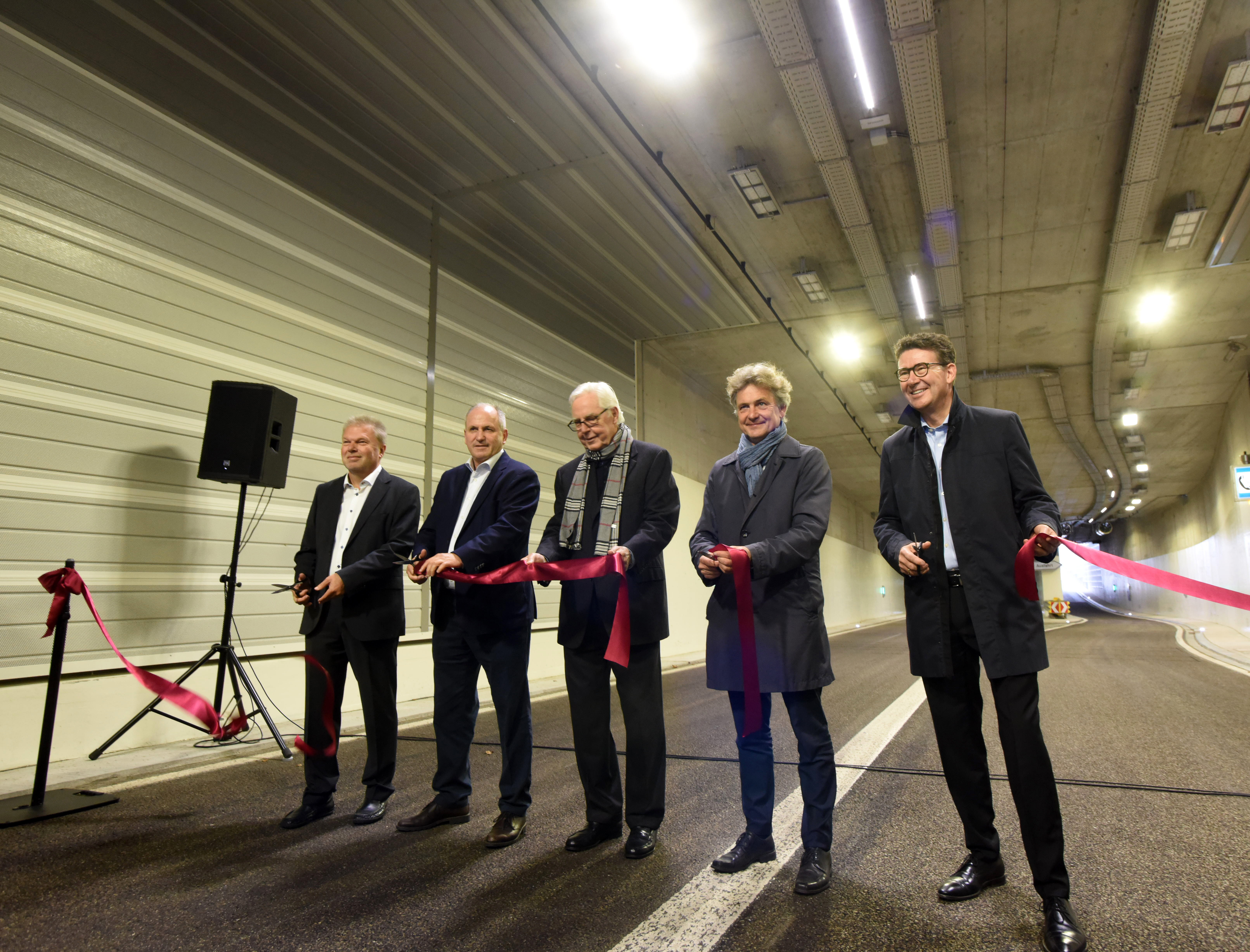 Fünf Herren schneiden ein rotes Band durch im Karoline-Luise-Tunnel.