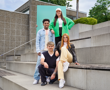 Eine Gruppe von fünf jungen Menschen blicken selbstbewusst in die Kamera