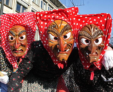 Drei Personen mit Hexenmasken.