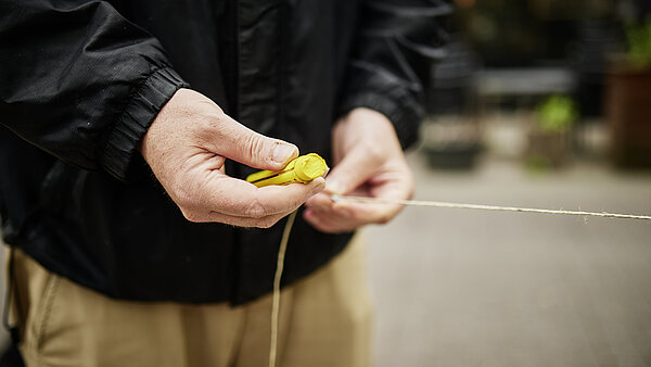 Hände mit Kreide beim Befestigen an einem Seil