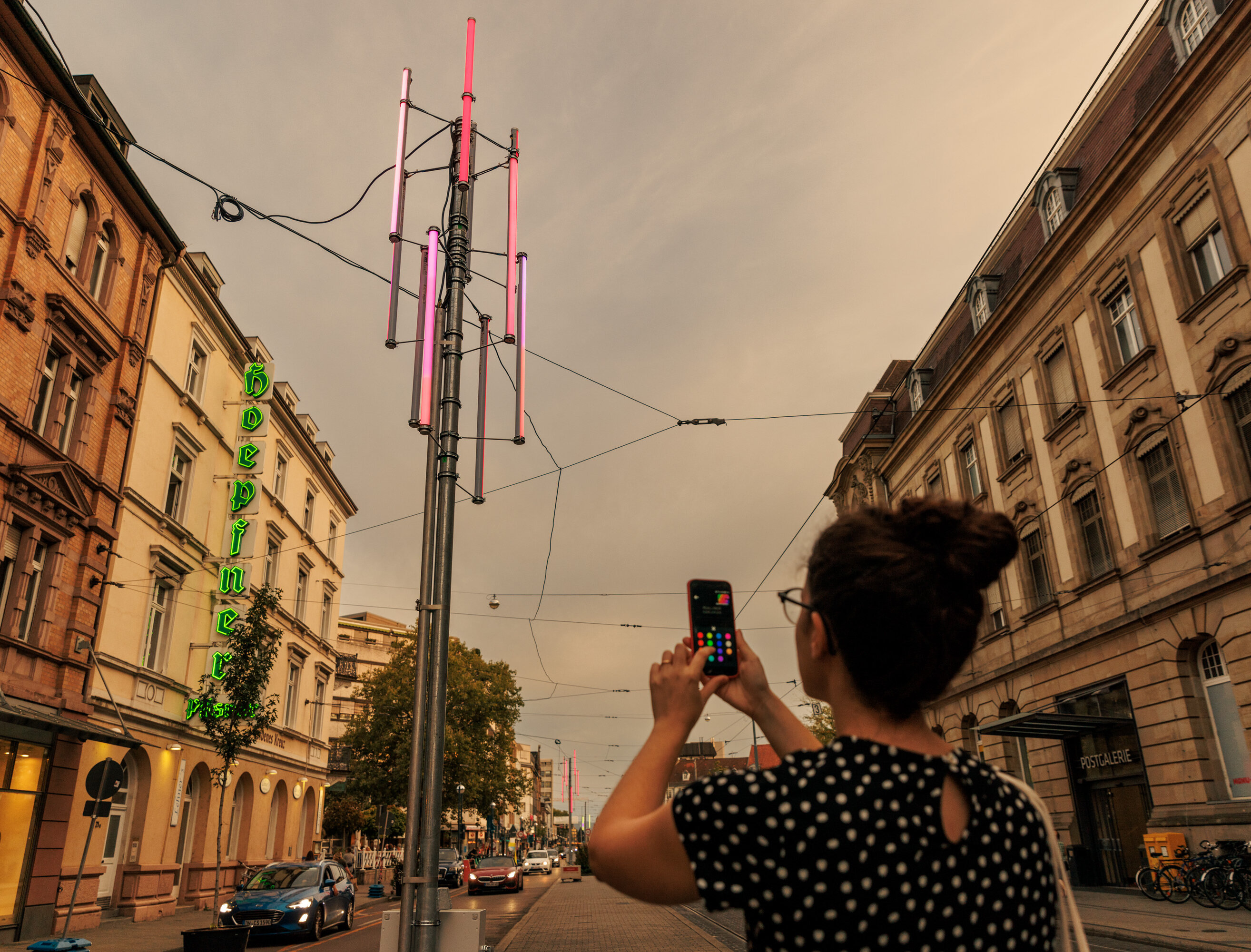 Frau mit Handy vor Beleucchtung