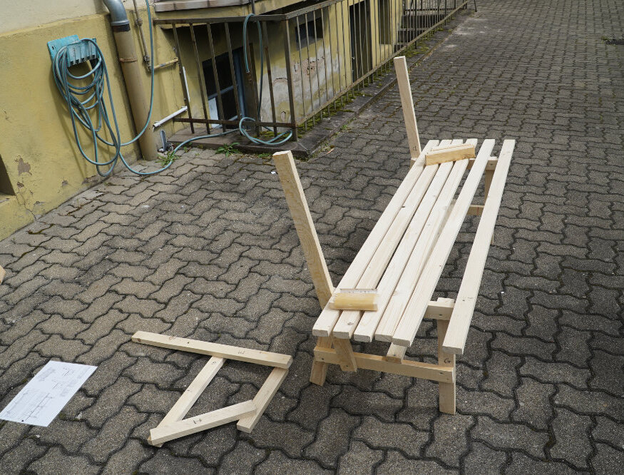 Halbfertige Bank, ohne Rückenlehne, die frei im Hinterhof steht.