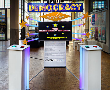 Im Las Vegas Stil: Große Tafeln mit The democracy machine. Drücken um Demokratie zu starten Aufschrift