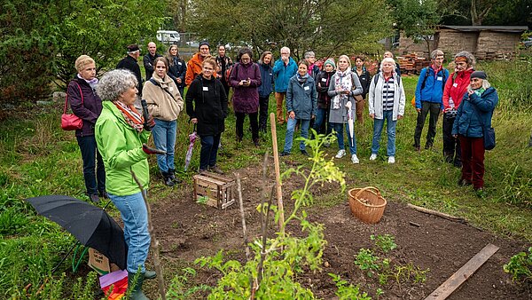 Eröffnung des Mitmach-Gartens, Besuchergruppe steht vor Beet