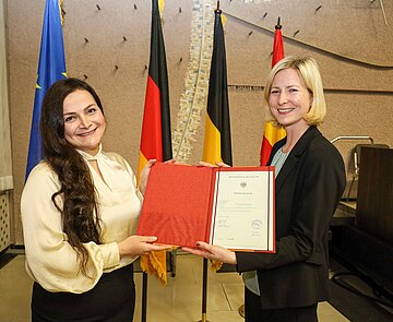 Bürgermeisterin Yvette Melchien (rechts)  überreicht Rama Laktineh ihre Einbürgerungsurkunde.