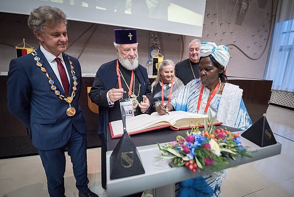 Goldenes Buch: OB Mentrup lädt Metropolit Nifon, Mary-Ann Swenson, Ioan Sauca und Agnes Abuom zum Unterzeichnen ein.