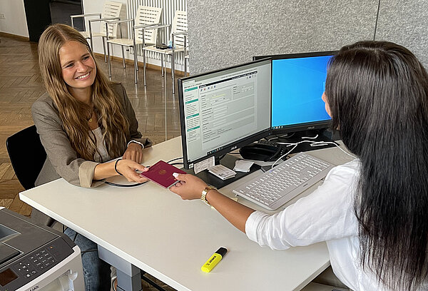 Junge Dame bekommt neuen Reisepass im Bürgerbüro