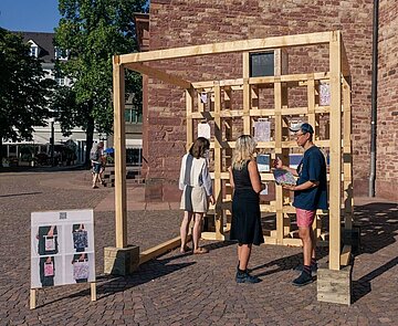 Der Künstler SangDoo Nam erklärt zwei Besucherinnen seine Arbeit.