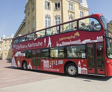 Das Bild zeigt einen HopOn/HopOff Bus vor dem Karlsruher Schloss.