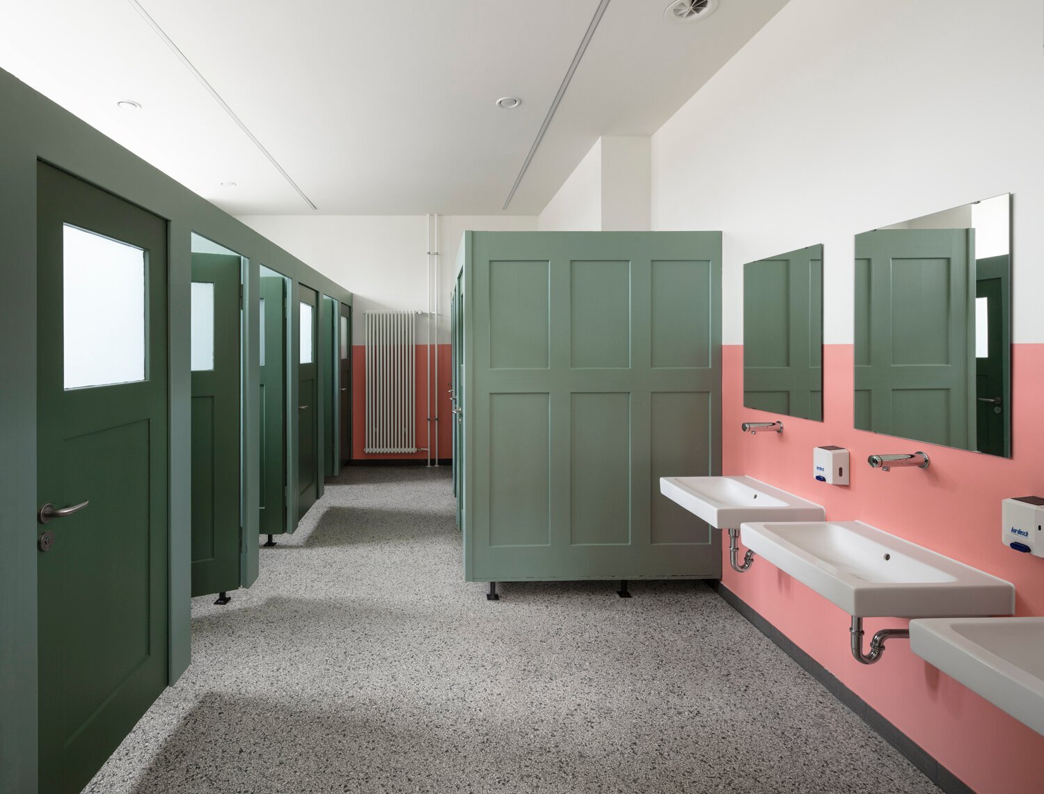 Blick in Toilettenbereich mit Waschbecken und Türen.