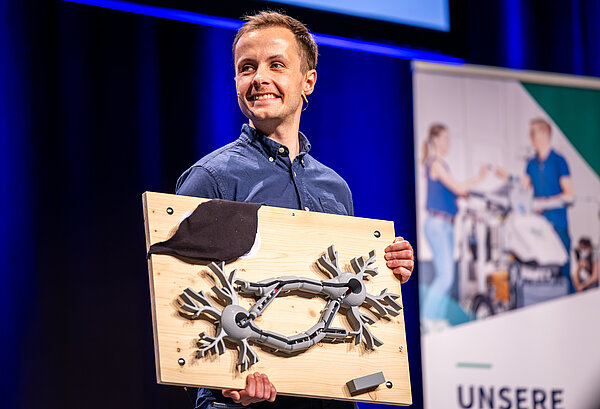 Ein FameLab-Kandidat zeigt seine Requisite während seines Vortrags