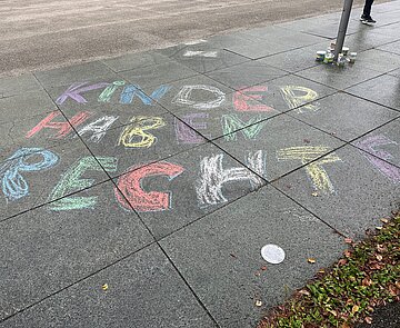 Straße auf der mit Kreide in Großbuchstaben Kinder haben recht geschrieben steht