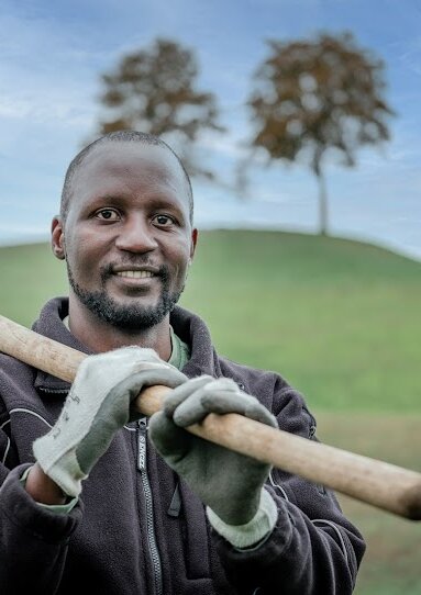 Junger Mann mit Schaufel über der Schulter