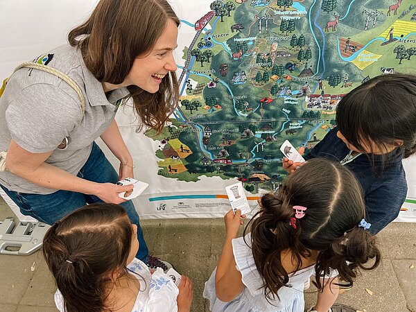 Die Naturpark-Bereichsleiterin für Bildung & Biodiversität, Fränze Stein, spielt mit Kindern des frisch ausgezeichneten Naturpark-Kindergartens Wettersbach in Karlsruhe-Palmbach das Naturpark-Quiz der Naturpark-Detektive. Dabei lernen sie das Gebiet des Naturparks Schwarzwald Mitte/Nord und seine Besonderheiten spielerisch kennen.